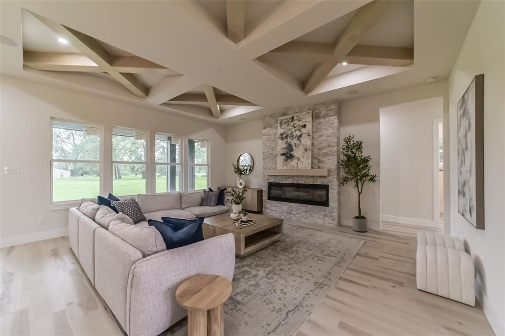 A living room with a large sectional couch and a fireplace