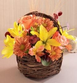 Wicker basket filled with bright yellow, orange, and peach flowers