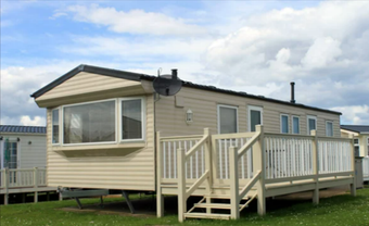 a mobile home sits in a grassy field