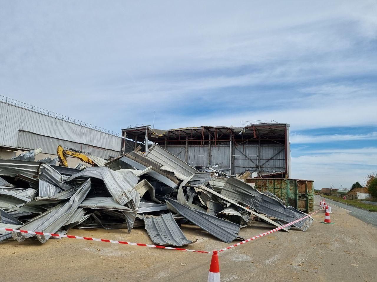 Un gros tas de métal se trouve devant un bâtiment.