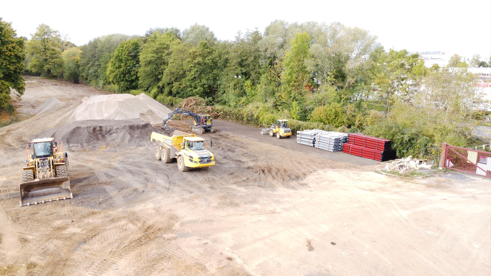 Une vue aérienne d'un chantier de construction avec des camions et des bulldozers.