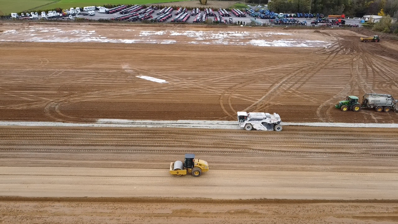 Une vue aérienne d'un chantier de construction avec des tracteurs et un rouleau.