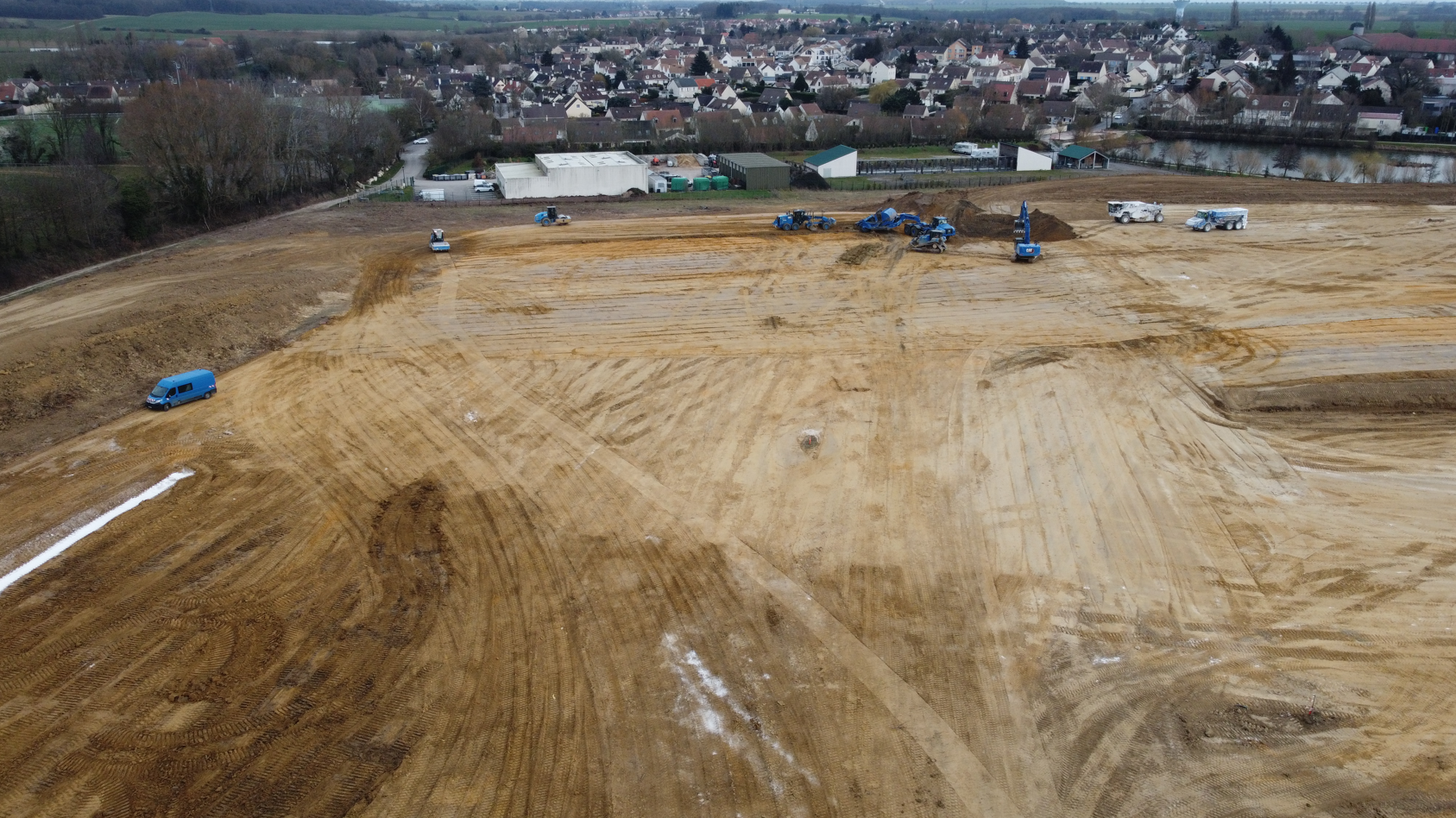 Une vue aérienne d'un chantier de construction avec une ville en arrière-plan.