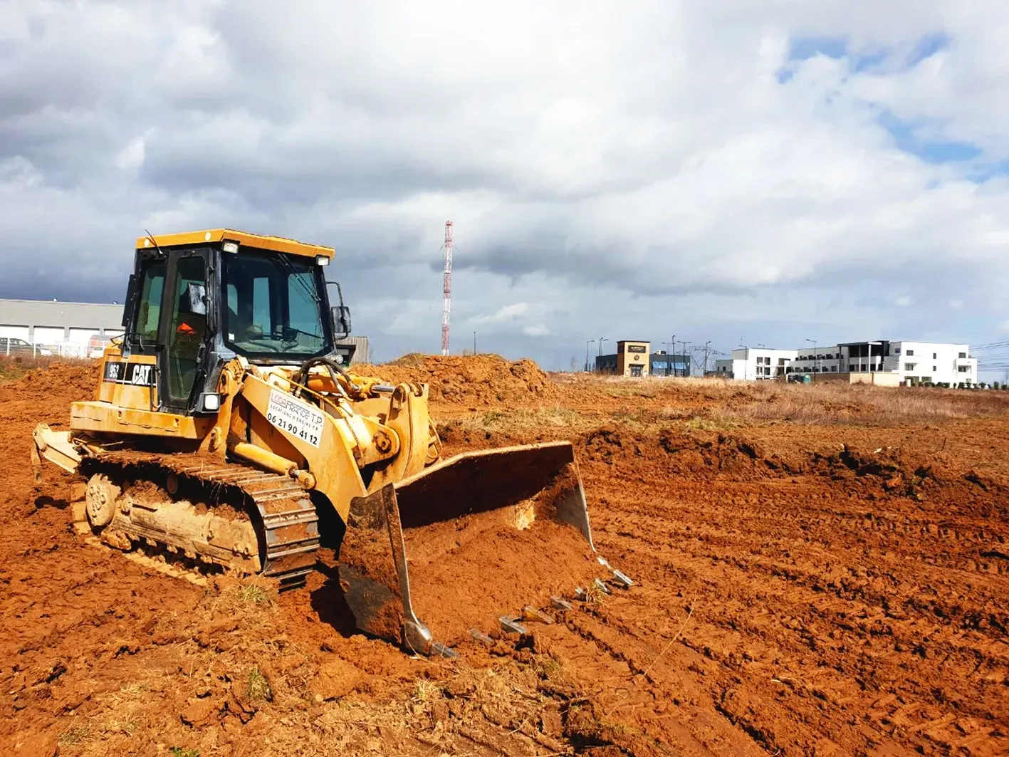 Un bulldozer déplace de la terre dans un champ.