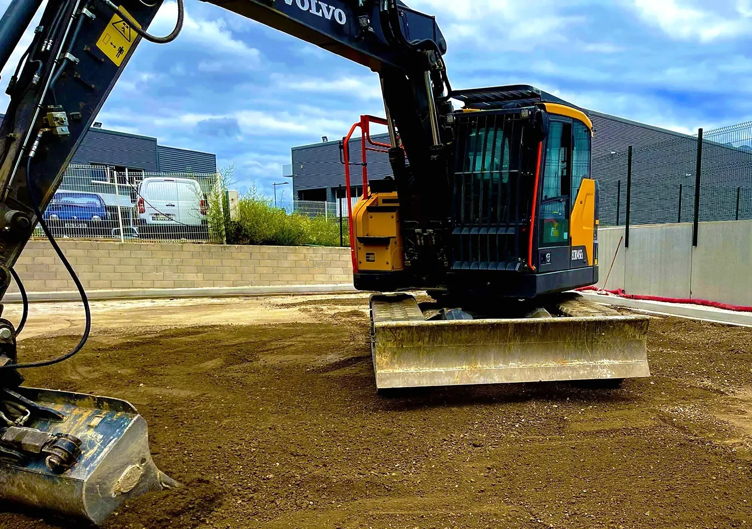 Une excavatrice jaune et noire est assise au sommet d'un champ de terre.