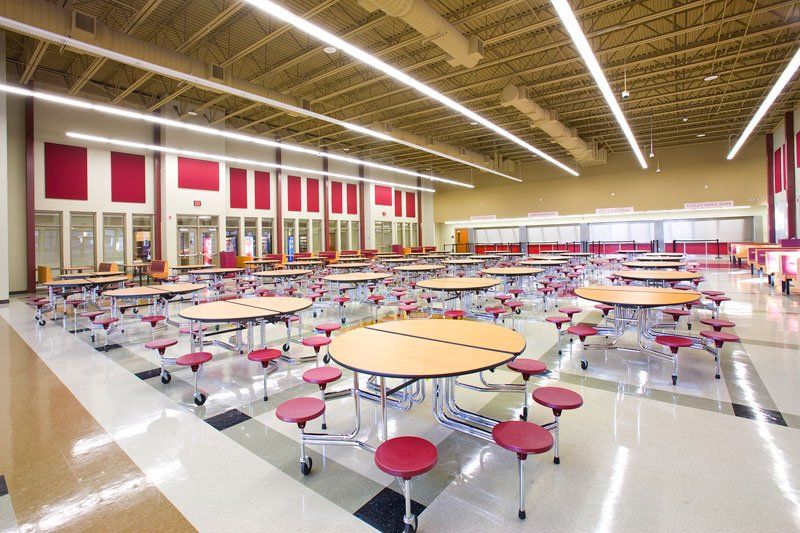 a school cafeteria with tables and chairs in it