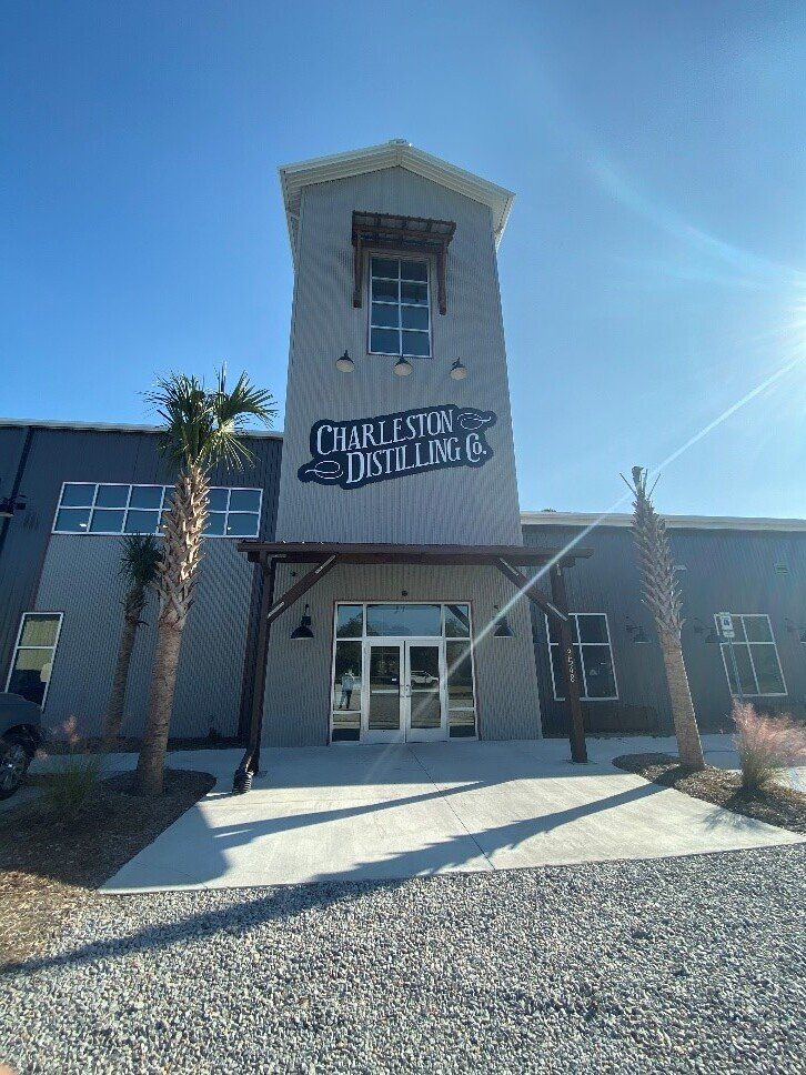 a large building with a tower on top of it and a sign that says charleston distillery .