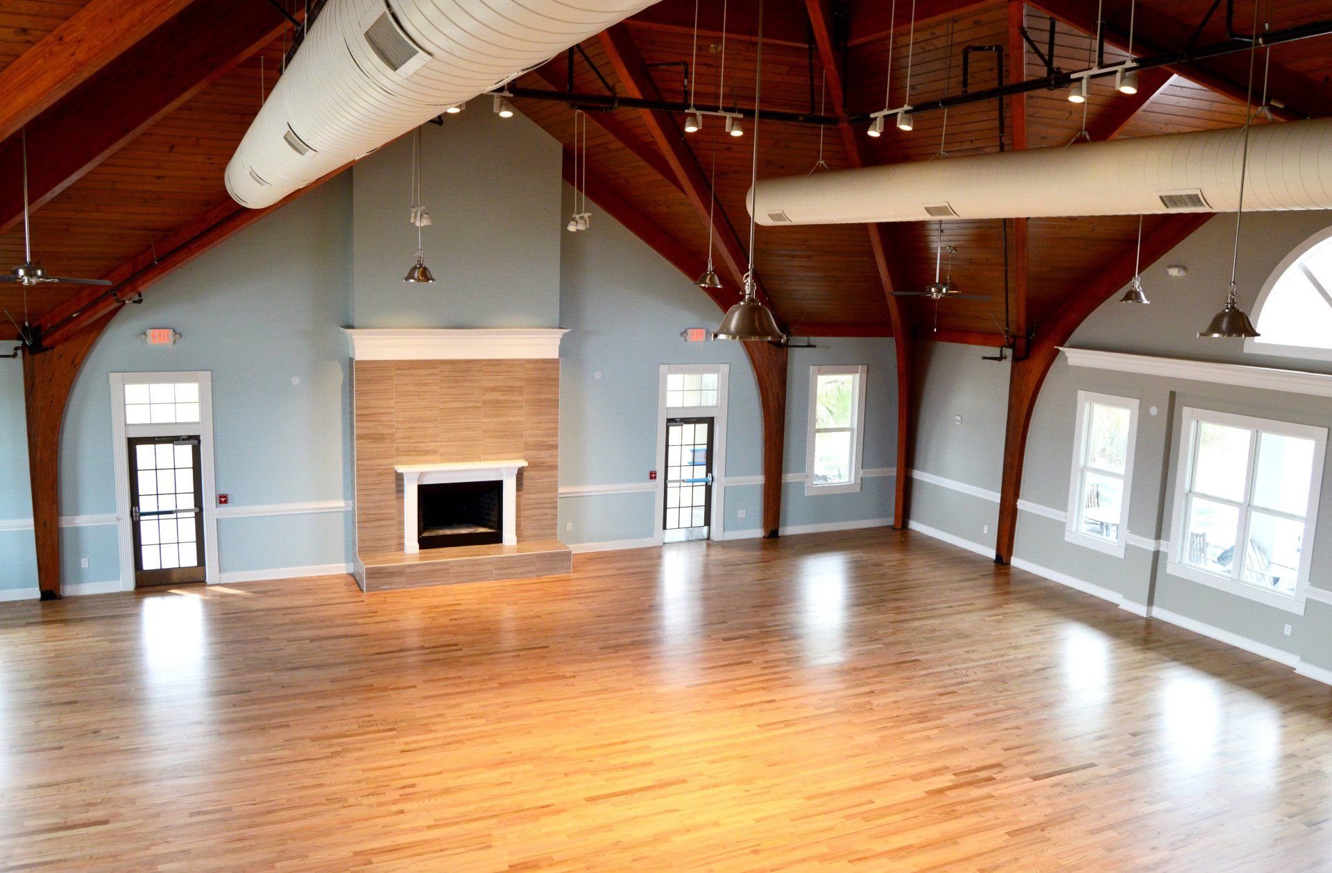 a large empty room with hardwood floors and a fireplace .
