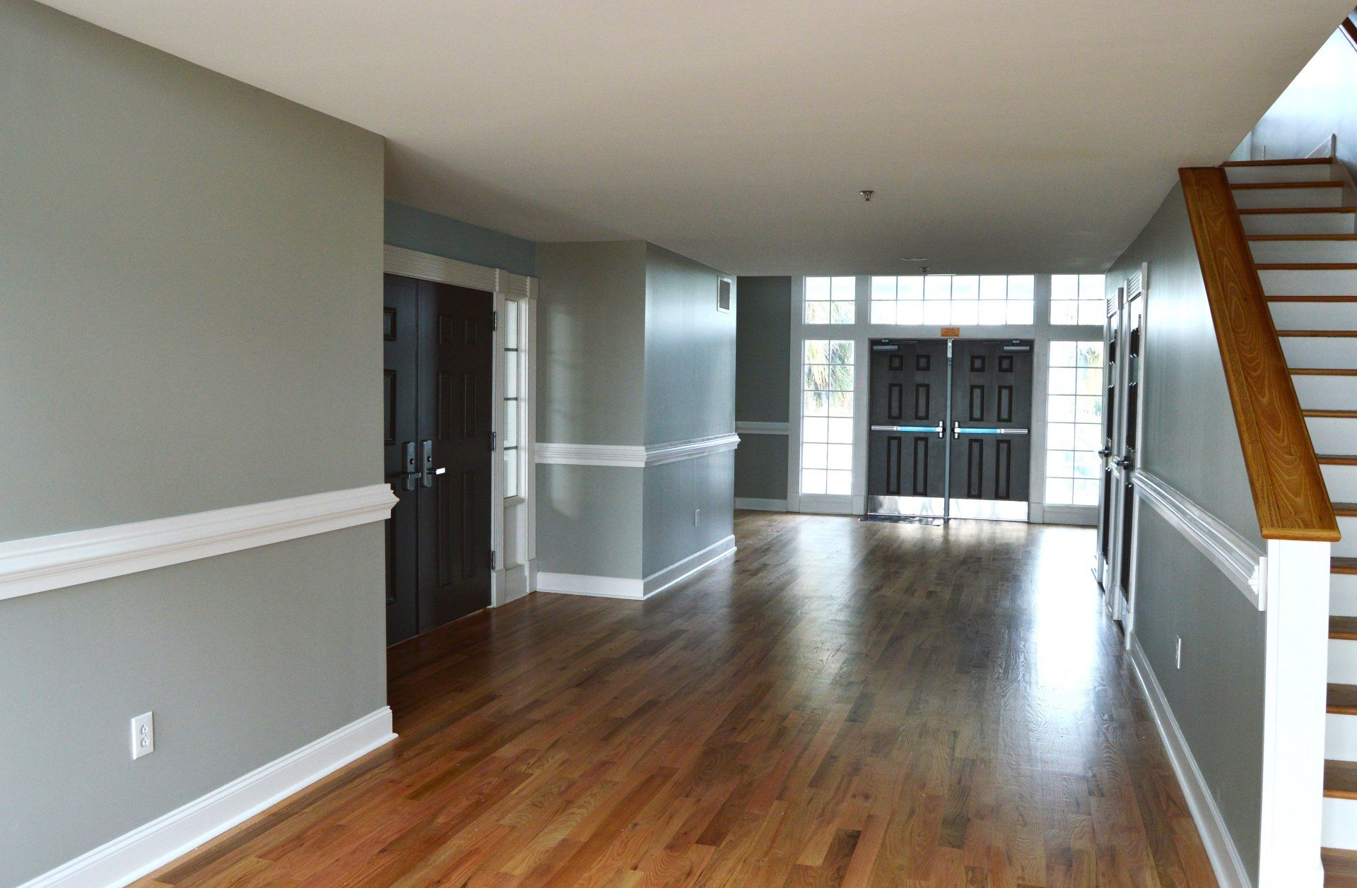 an empty hallway with hardwood floors and stairs in a house