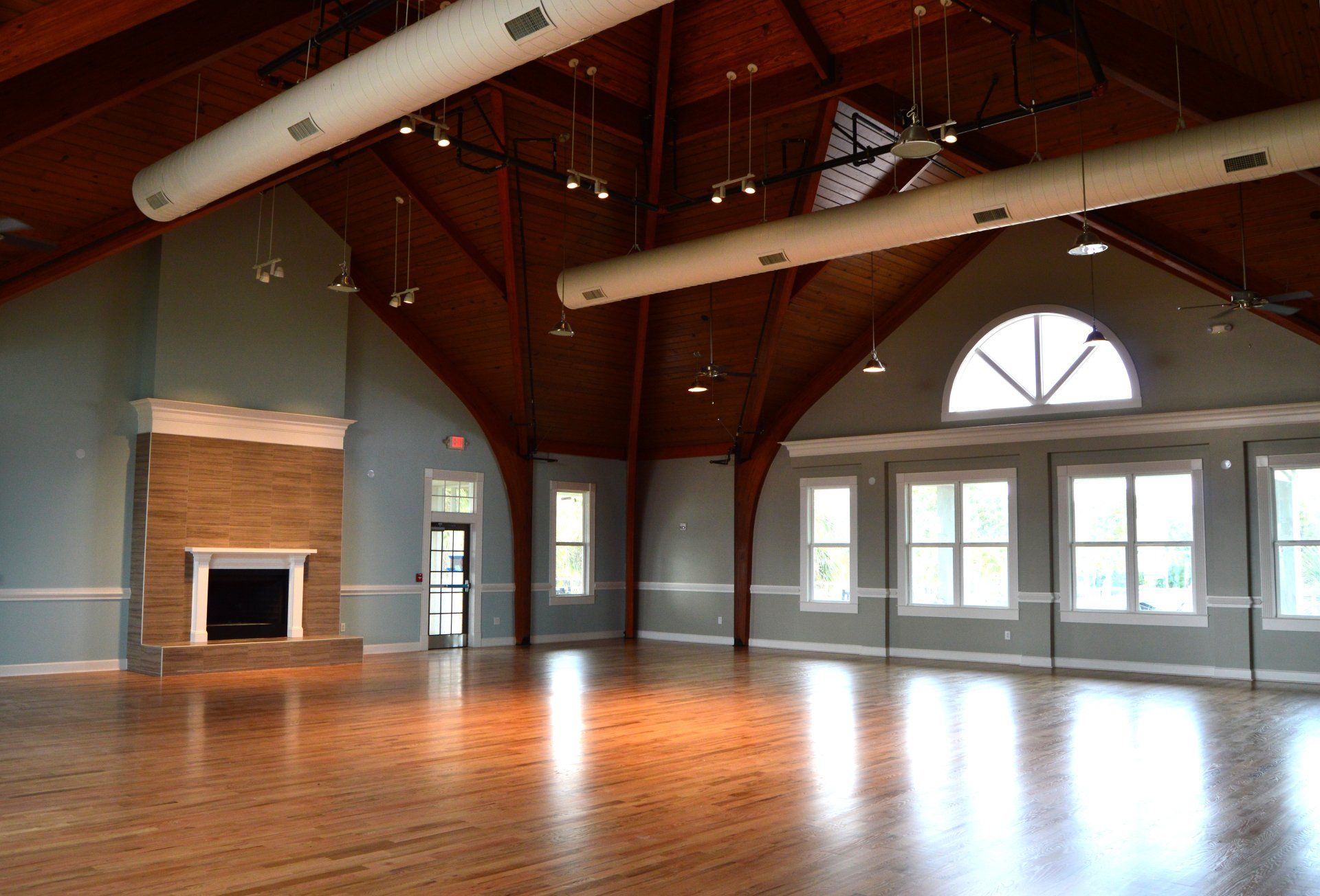 a large empty room with hardwood floors and a fireplace