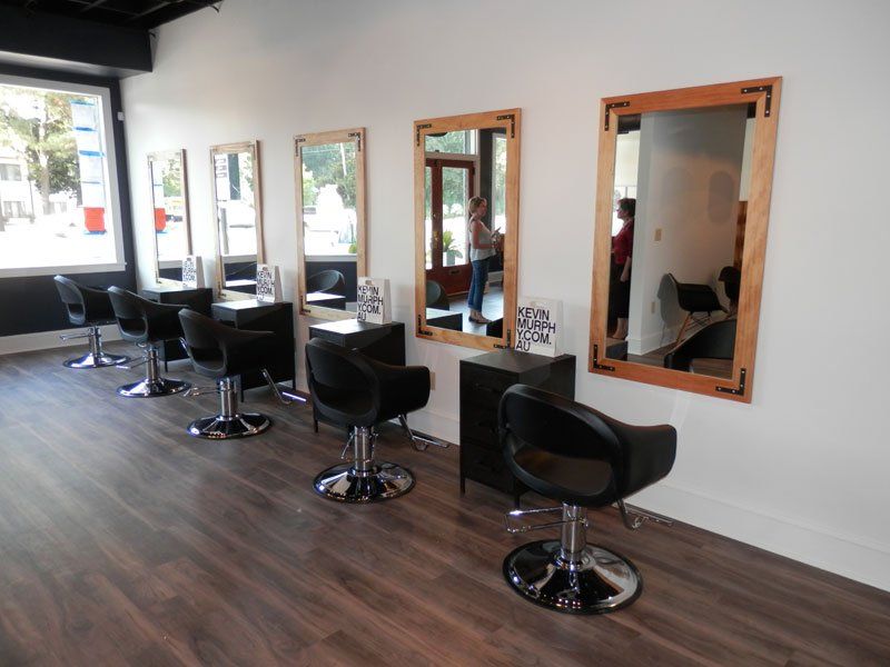 a row of chairs and mirrors in a hair salon