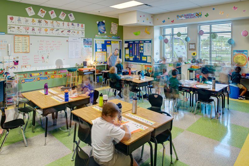 a group of children are sitting at desks in a classroom .
