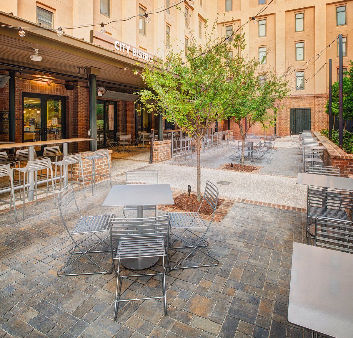 a patio with tables and chairs in front of a building