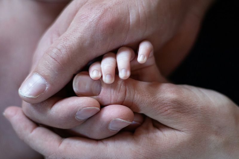 Infant hand being held