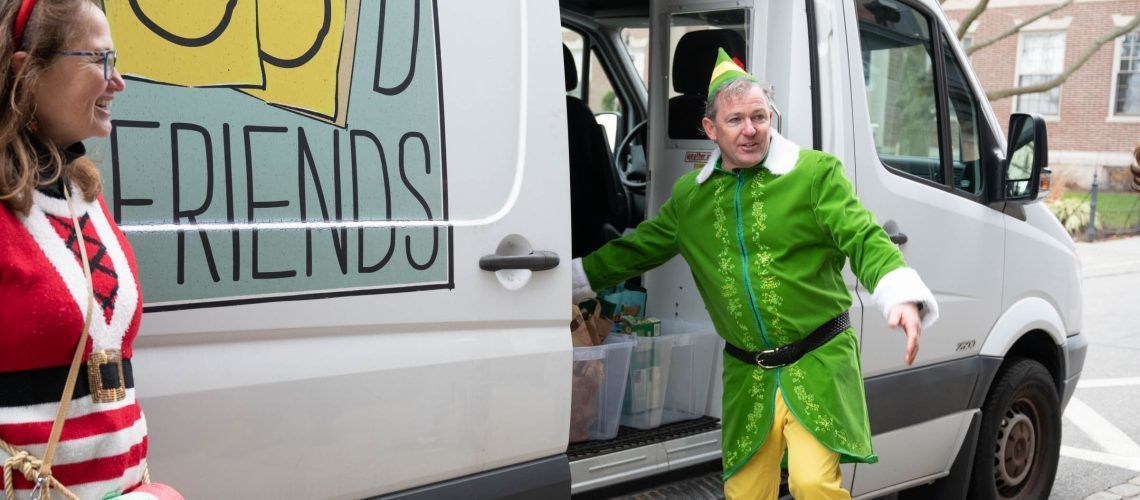 A man dressed as an elf is getting out of a van.