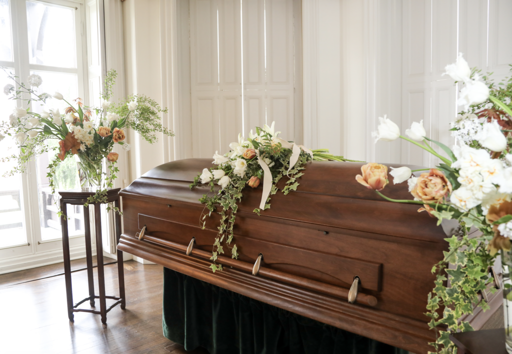 a wooden coffin is sitting in a room decorated with flowers .