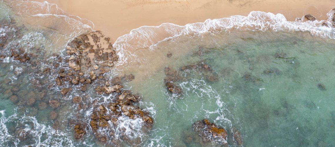 an aerial view of waves crashing on a rocky beach .