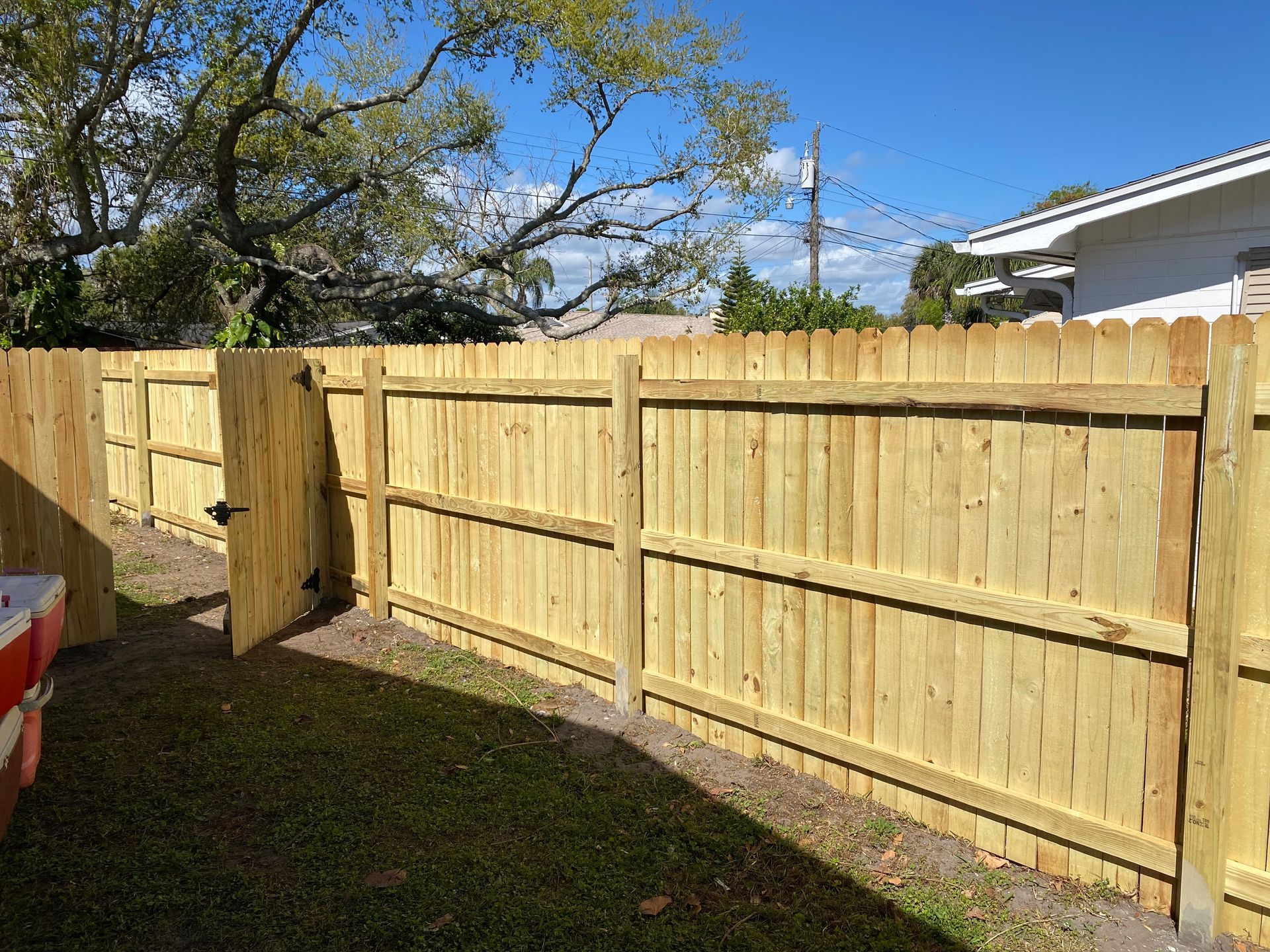 A white picket fence with a green leaf attached to it