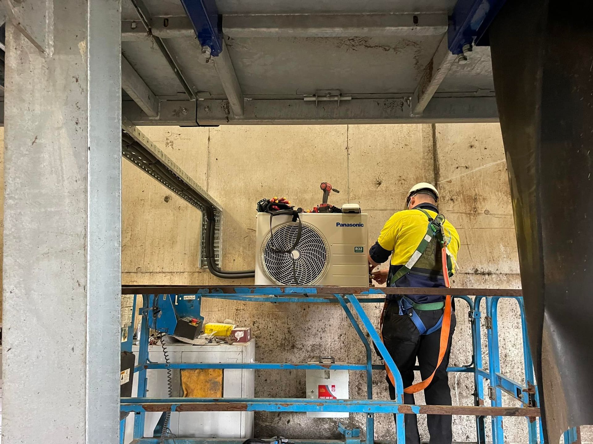 Worker on A Lift Installing An HVAC unit in An Industrial Setting — Leader Air Conditioning in Wagga Wagga, NSW