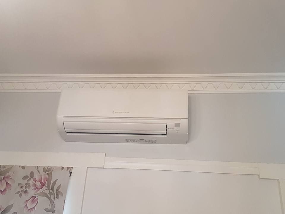 White Wall-Mounted Air Conditioning Unit on A Light Grey Wall — Leader Air Conditioning in Queanbeyan, NSW