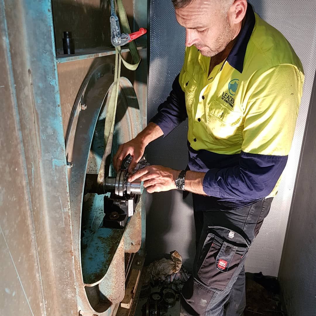 Mechanic in Work Clothes Working on Machinery — Leader Air Conditioning in Queanbeyan, NSW