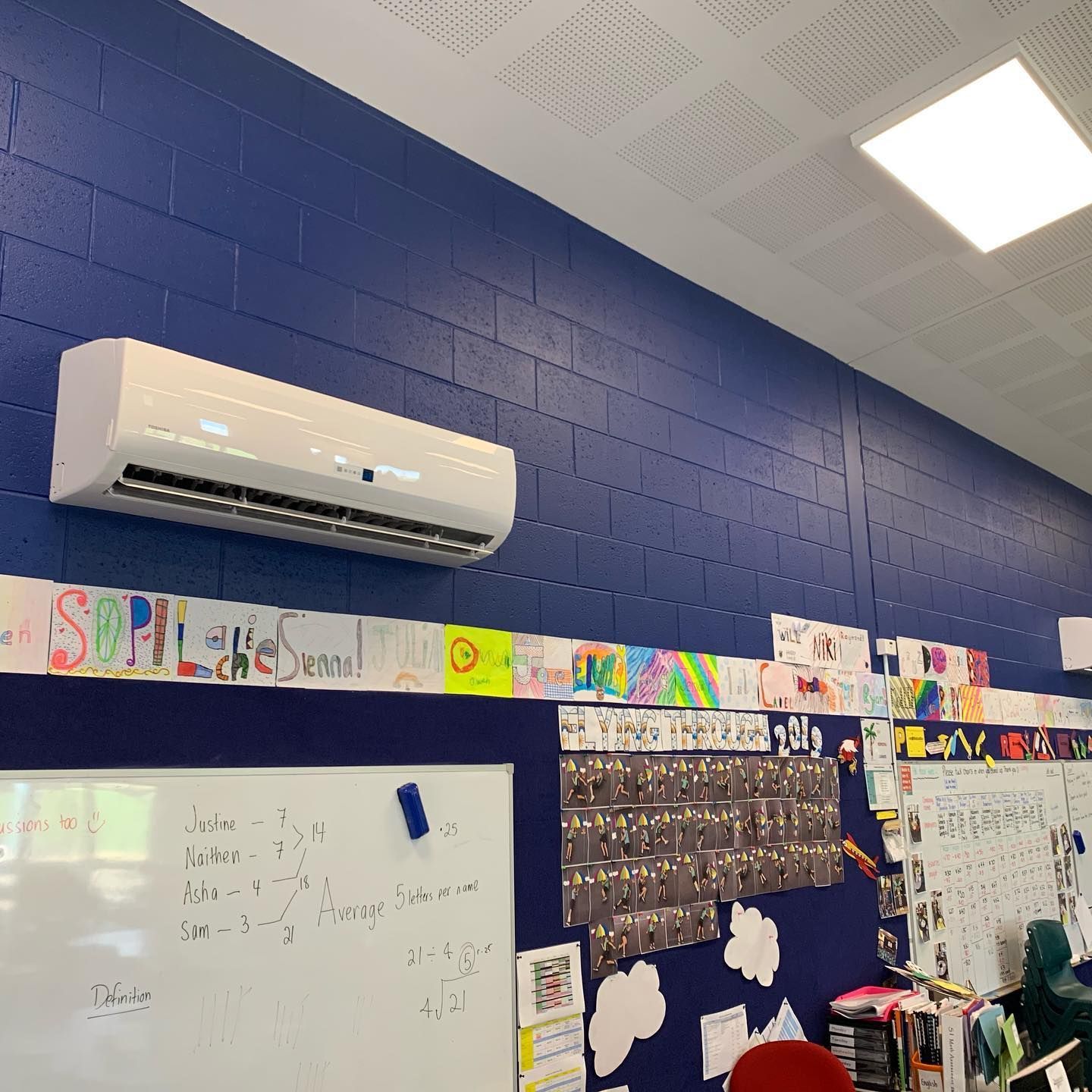 Air Conditioning Unit on A Blue Classroom Wall — Leader Air Conditioning in Queanbeyan, NSW