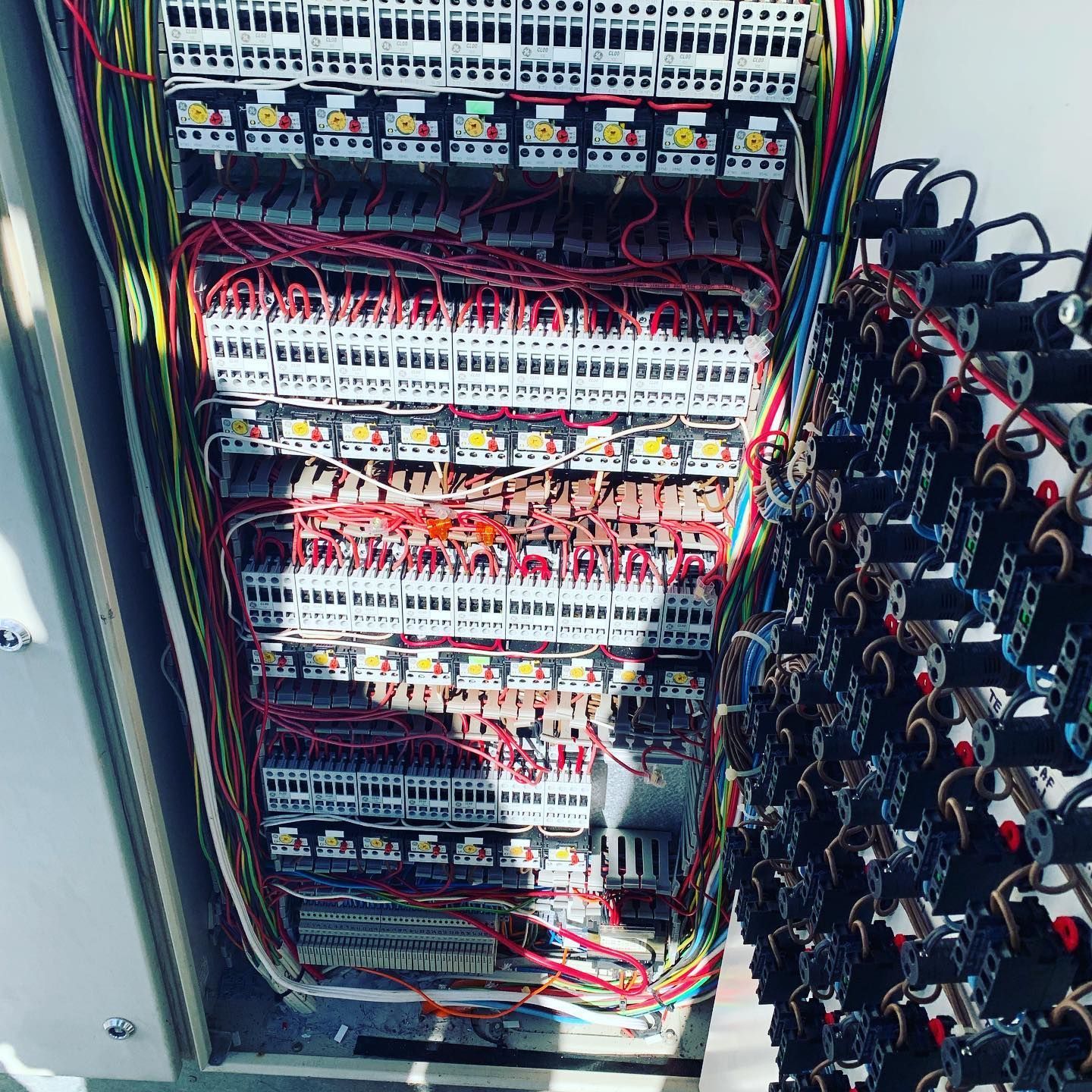 Interior of an electrical panel filled with wiring, terminal blocks, and components; multi-colored wires. — Leader Air Conditioning in Queanbeyan, NSW