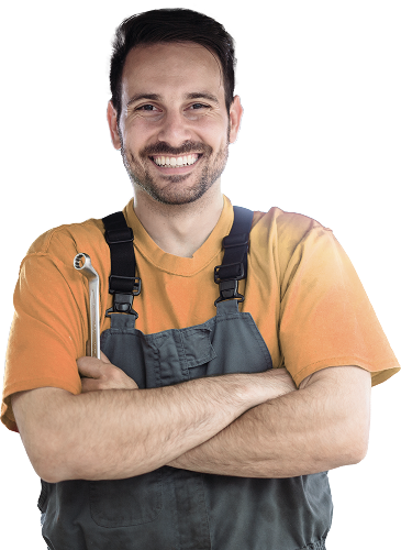 Smiling mechanic with crossed arms, holding a wrench, wearing overalls and a yellow shirt. | Jeremi's Auto Repair