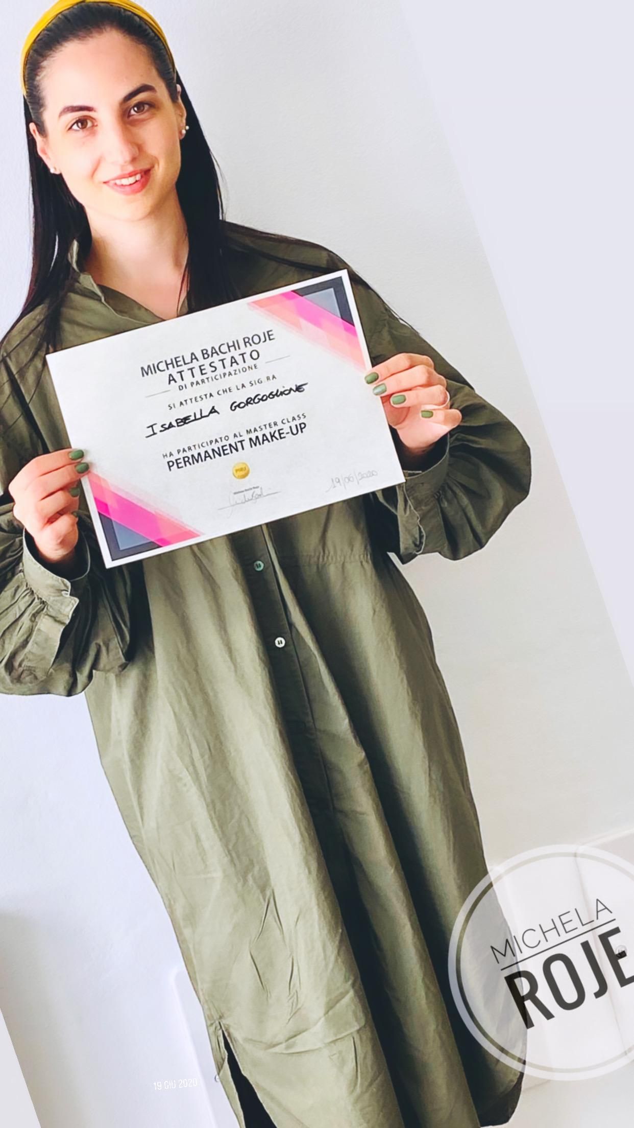 Una donna con un vestito verde tiene in mano un certificato.