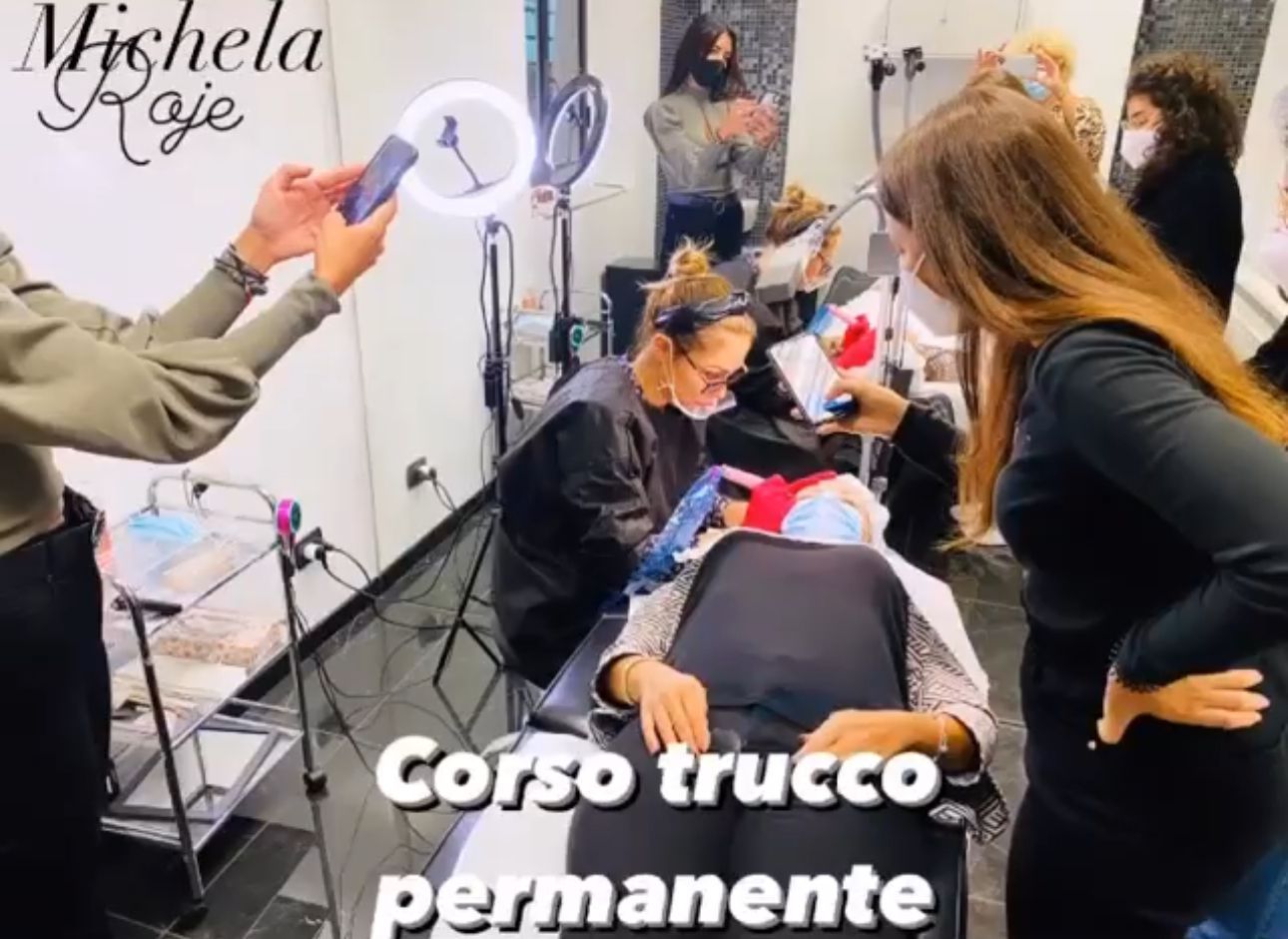 Un gruppo di persone in una stanza con la scritta corso trucco permanente sul fondo
