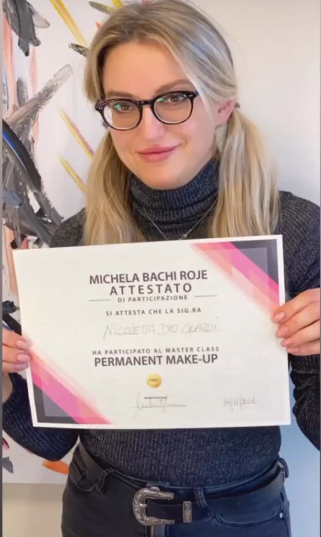 Una donna tiene in mano un certificato che dice trucco permanente