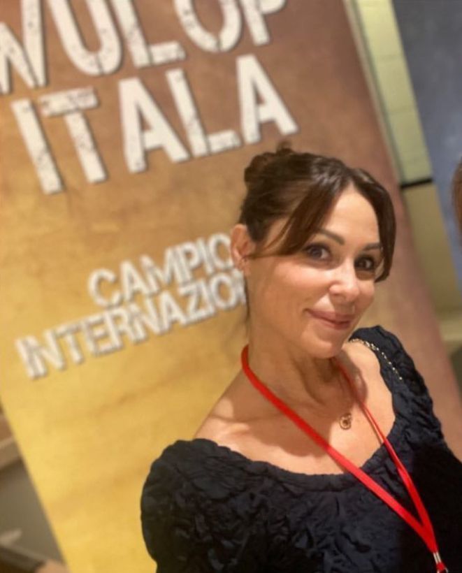 Una donna è in piedi davanti a un cartello che dice molto italia