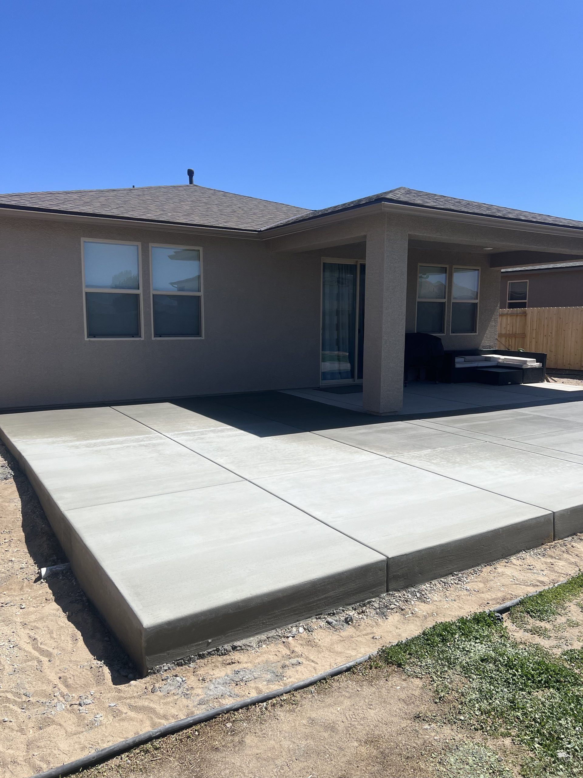 A concrete patio is being built in front of a house.