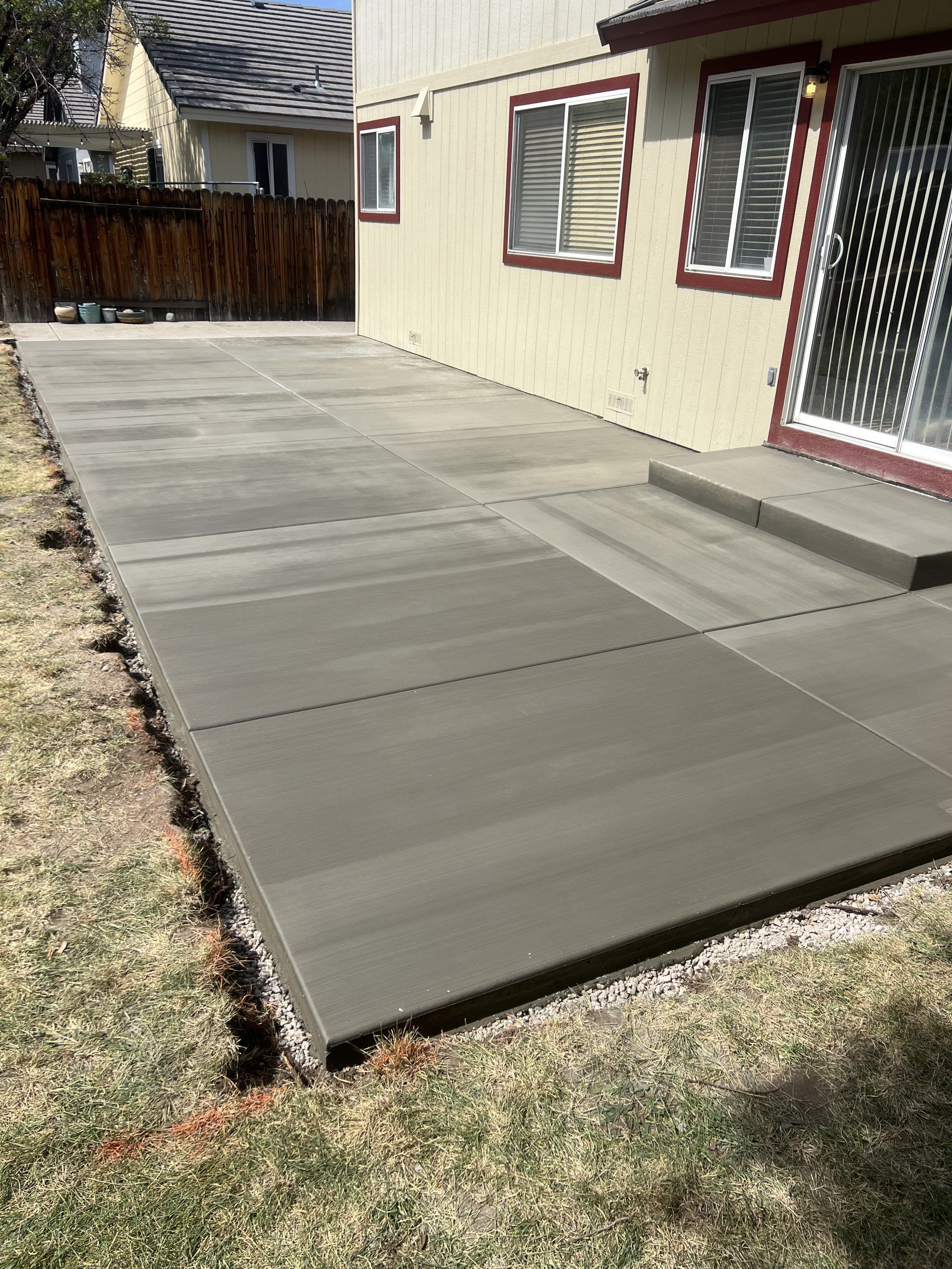 A concrete patio is being built in front of a house.
