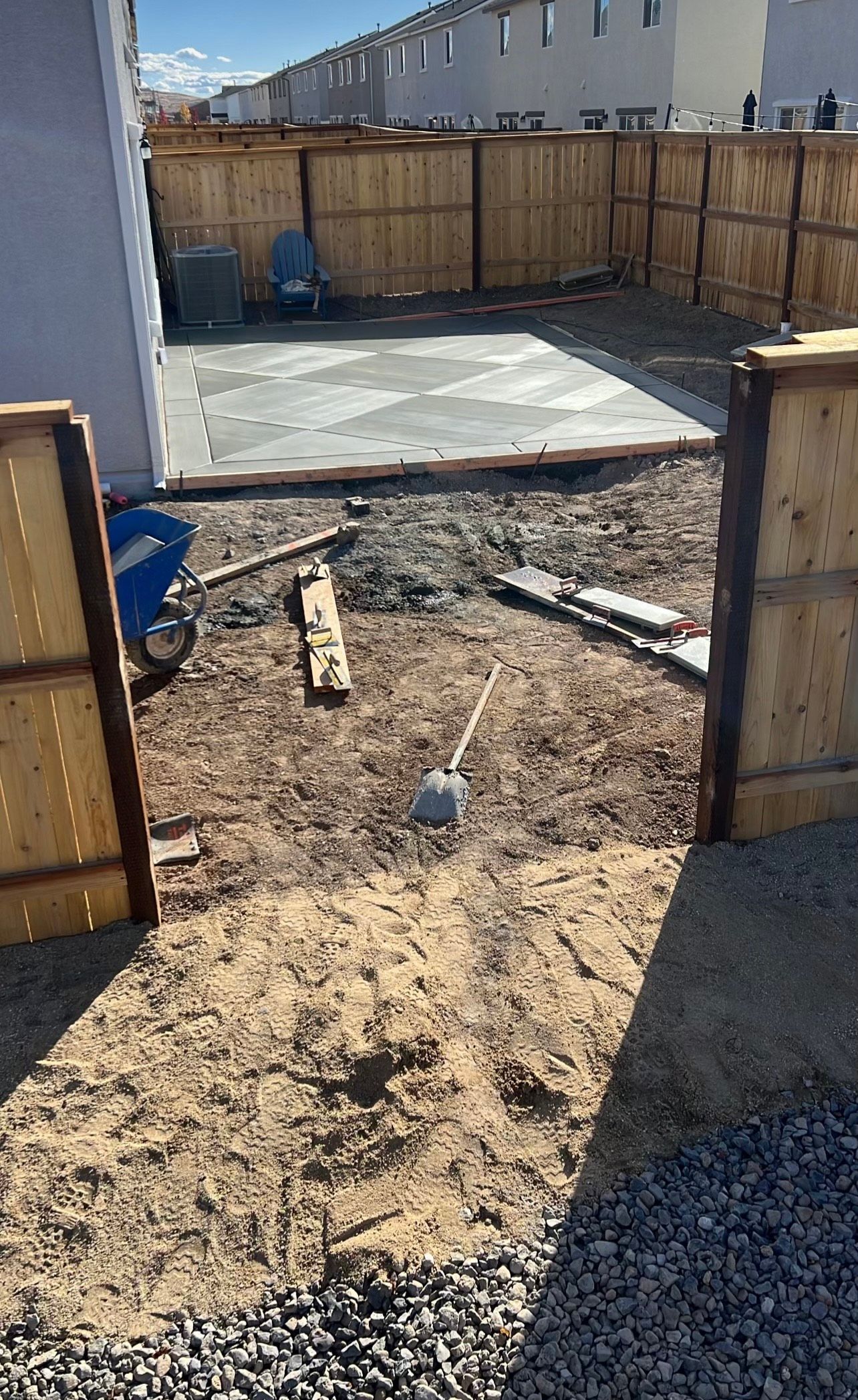 A fence is being built around a concrete slab in a backyard.