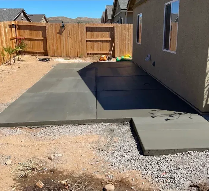 A concrete patio is being built in front of a house