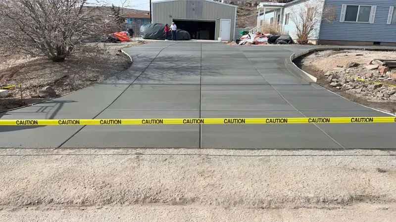 A concrete driveway is being built in front of a house.