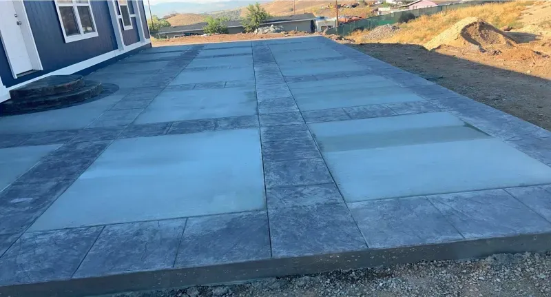 A concrete driveway is being built in front of a house.