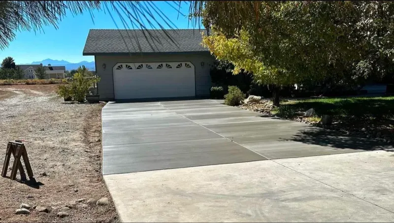 A concrete driveway leading to a garage with a white garage door.