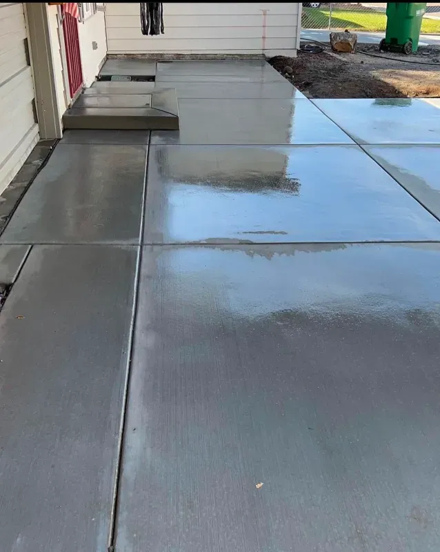 A concrete walkway is being built in front of a house.