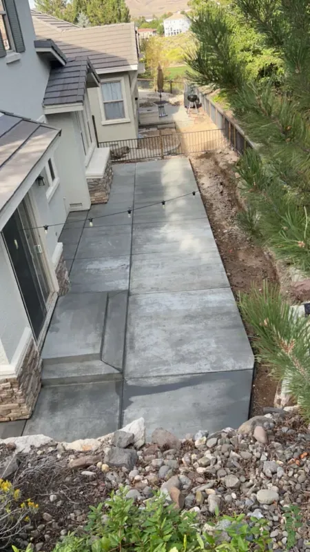 A concrete walkway is being built in front of a house.