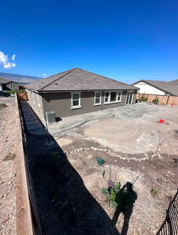 An aerial view of a house with a fence in front of it.