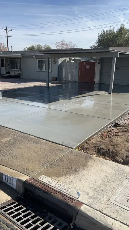 A concrete driveway is being built in front of a house.