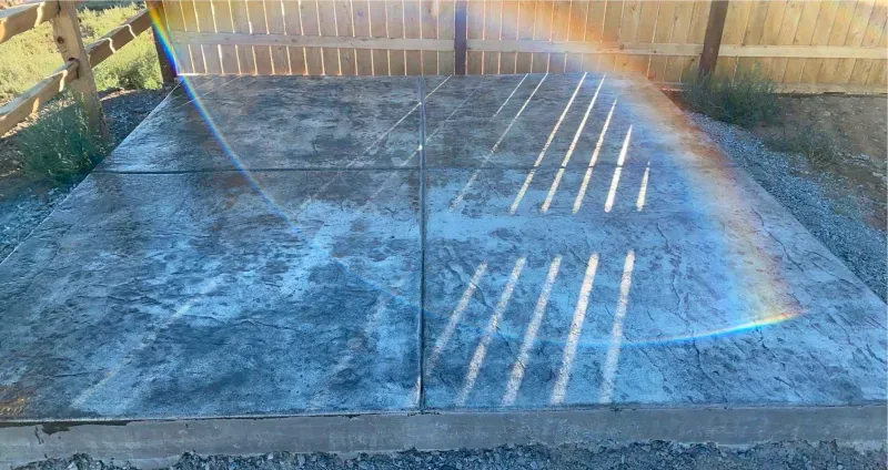 A rainbow is reflected in a concrete surface.