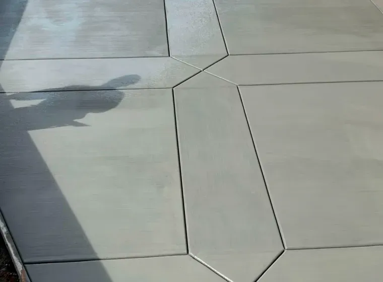 A shadow of a person is cast on a concrete floor.