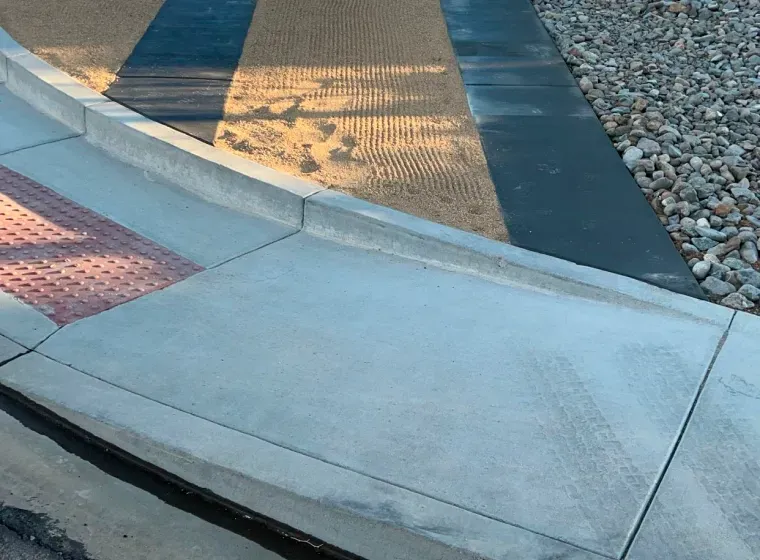 A concrete sidewalk with a red stripe on it