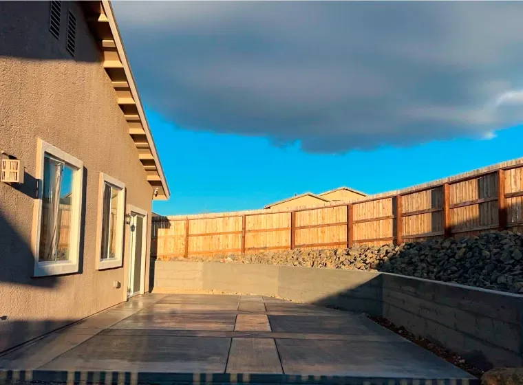 A house with a fence and a patio in front of it