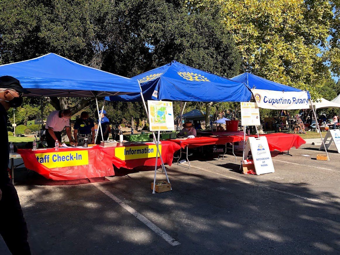 A man is standing in front of a booth that says fall check in