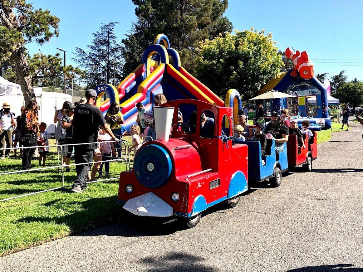 A group of children are riding a train down a road.