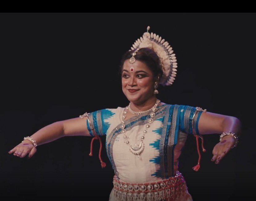 A woman in a blue and white dress is dancing